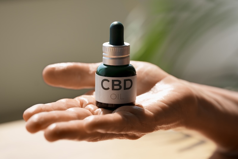 Hand som håller en CBD-flaska